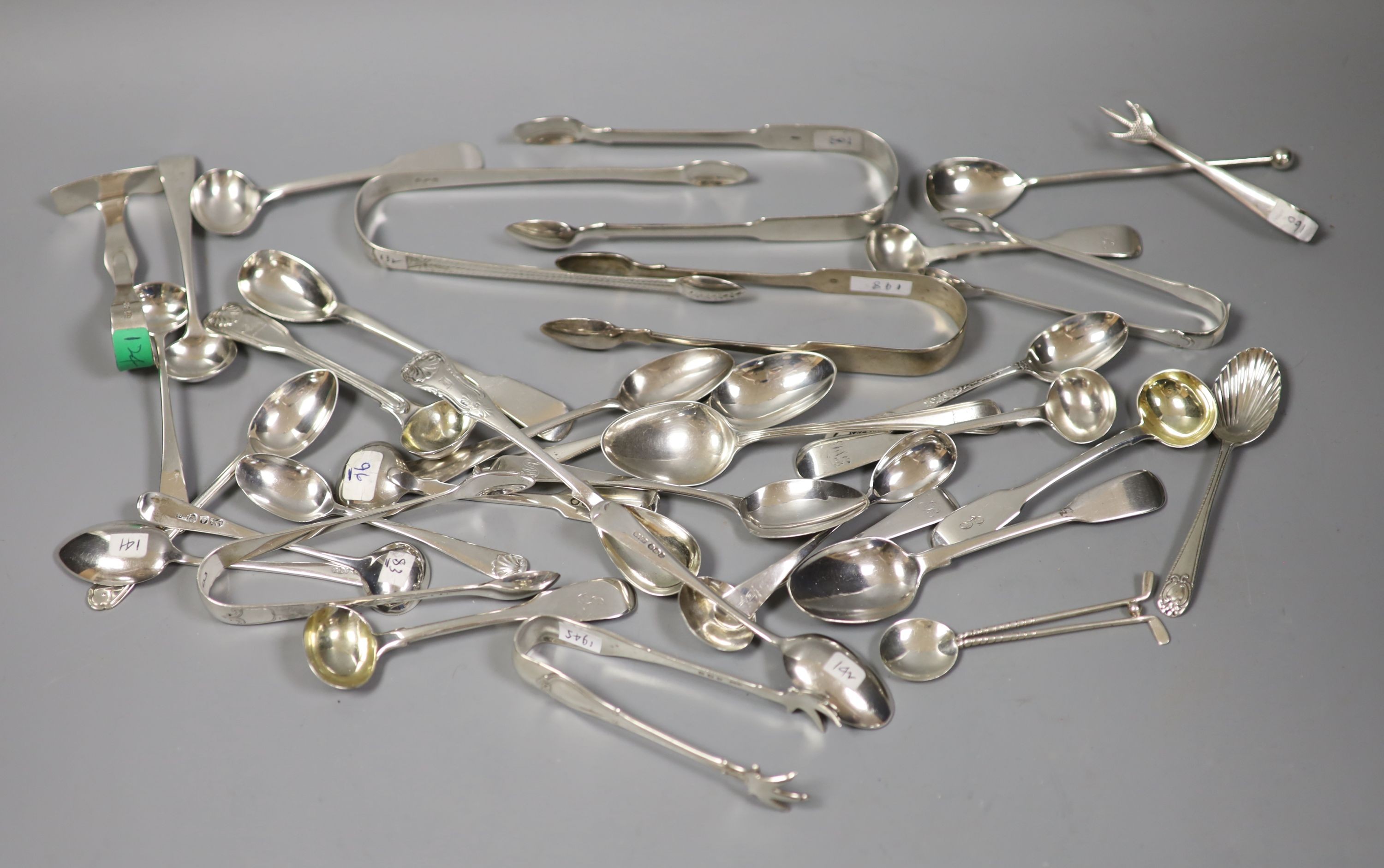 A quantity of assorted silver flatware including Georgian and later sugar tongs, condiment spoons etc.18oz.